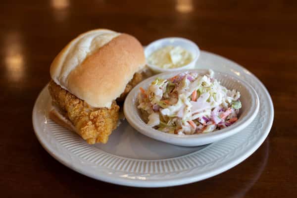 fried chicken sandwich on a bun with a side of coleslaw