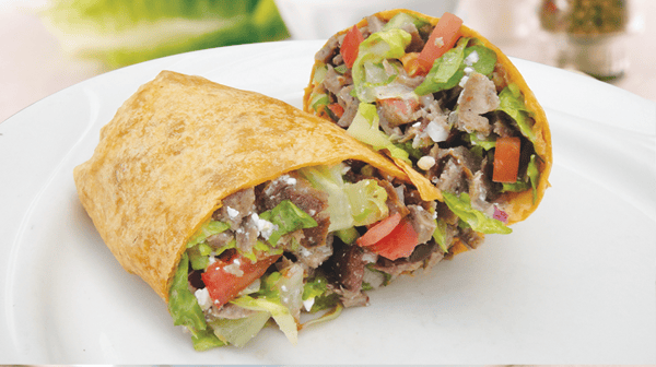 Mediterranean Wrap Filled with chopped lettuce, tomatoes, red onions, feta cheese and authentic gyros meat and drizzled with a Greek vinaigrette.