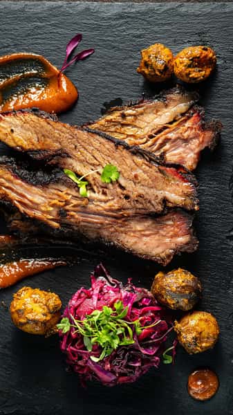 This is the kind of thirst trap we can get behind 🔥

Coated in Indian spices and smoked over apple and mesquite wood for 14 to 18 hours, our melt in your mouth masala brisket is fork tender with a dark, smoky bark. Served with roasted potato wedges and our house barbecue chutney.

Give in to the craving. Reservations through the link in our bio.