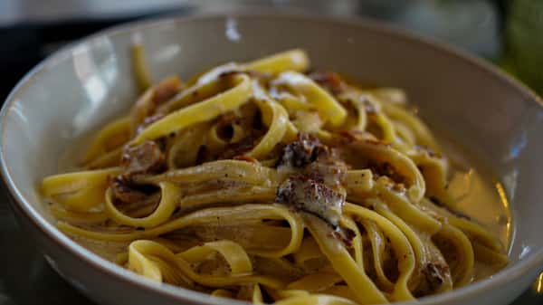 popmenu-close-up-of-creamy-fettuccine-carbonara-with-bacon-in-a-bowl-original.jpg