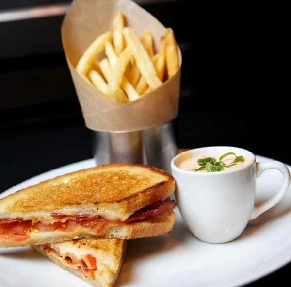 Grilled cheese with bacon with side of fries and a cup of soup