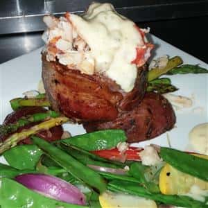 menu item with grilled vegetables and an open baked potato with seafood on top
