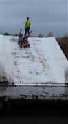 two girls sliding down the slide into a lake