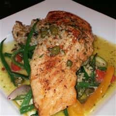 grilled seafood item on a bed of grilled vegetables