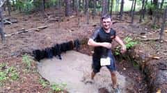 boy in a mud puddle competing mud run 2015 course