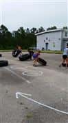 People pushing tires over competing mud run 2015 course