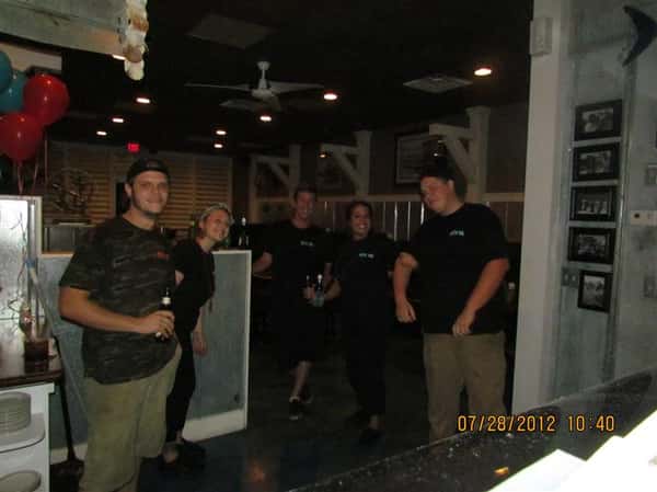 Workers smiling by the front of the restaurant