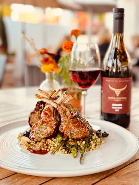 Rack of lamb with a glass of wine in the background