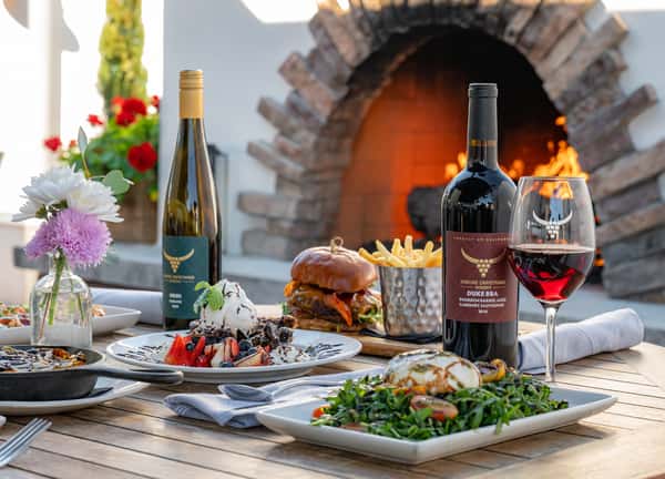 A table spread full of entrees and wine