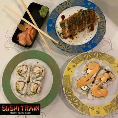 Assorted sushi rolls served on multiple plates with chopsticks