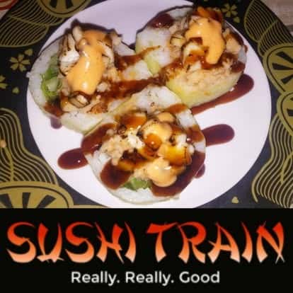 Plate of sushi rolls topped with sauce and garnish, Sushi Train promotional photo