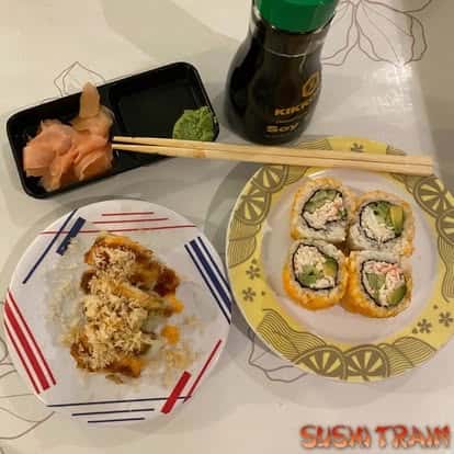 Sushi rolls served with chopsticks and soy sauce on a decorative plate