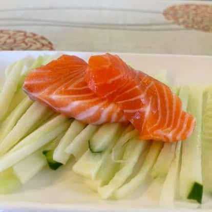 Fresh salmon sashimi slices served with cucumber