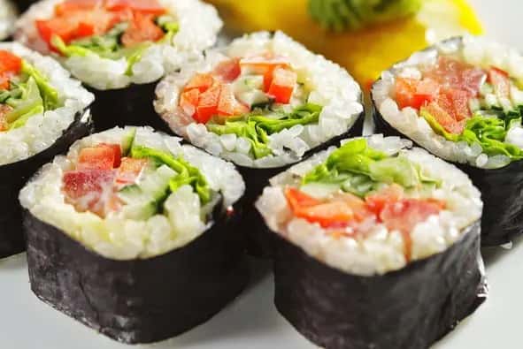 Close-up of fresh sushi rolls with rice and vegetables, served on a plate