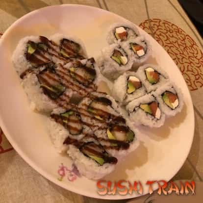 Plate of sushi rolls and grilled eel drizzled with sauce