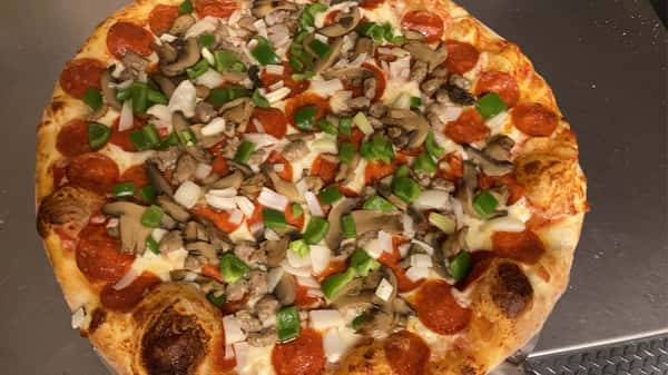 Crispy fried chicken salad served on a bed of shredded lettuce, tomatoes, green peppers, shredded cheese, and crunchy croutons. Presented in a bowl with a red-and-white checkered paper underneath, accompanied by a fork and knife.