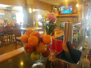 fruit in a bowl and flowers on the bar