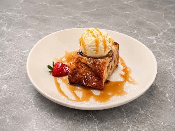 Warm bread pudding topped with vanilla ice cream and caramel drizzle at Local on North, a Southern-inspired dessert favorite in Canton and Marietta.