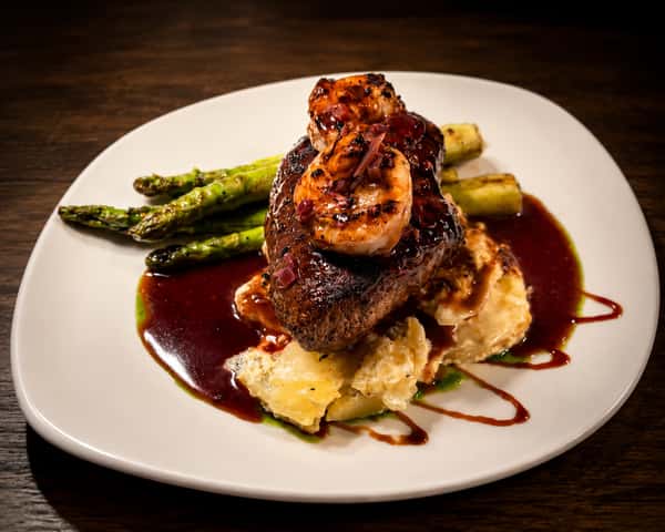 Surf and turf featuring grilled steak and jumbo shrimp over creamy mashed potatoes with asparagus at Local on North.