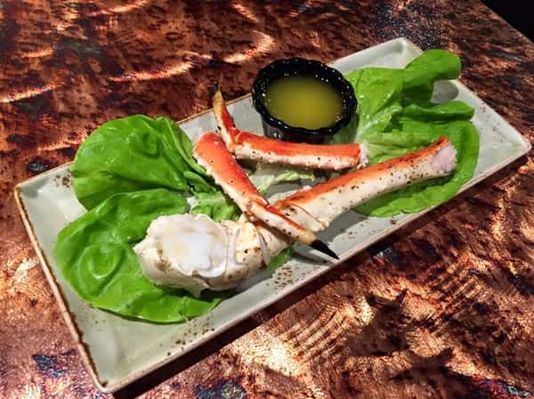 Crab legs over lettuce with a side of melted butter