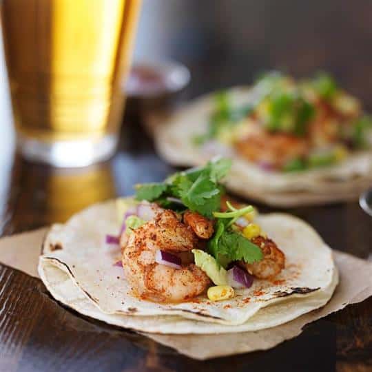 Shrimp tacos with cilantro, corn, and red onion