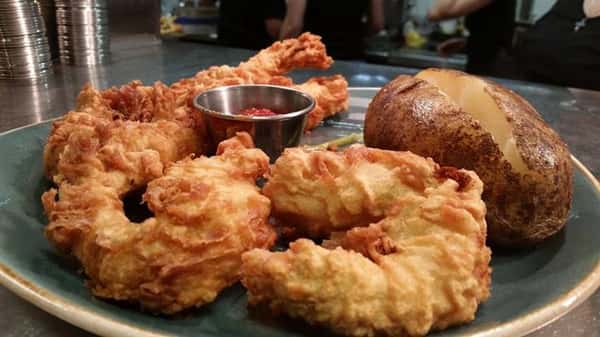 Fried fish with side of potato and red sauce