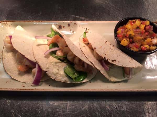Shrimp tacos with lettuce and red onion. Pico de gallo on the side