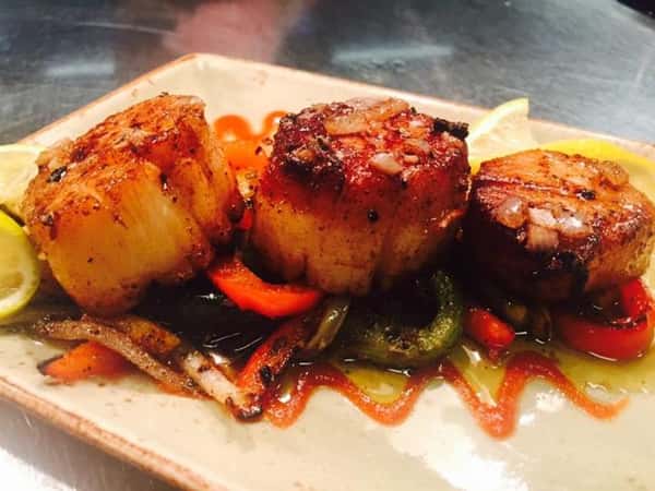 scallops on top of peppers and onions