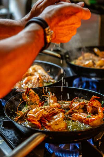 A chef cooking a meal of shrimps