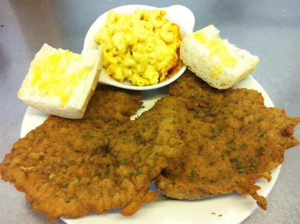 two pieces of country fried steak with two pieces of bread and mac and cheese