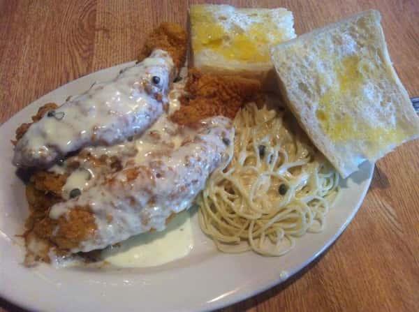 fried fish smothered in gravy with noodles and bread
