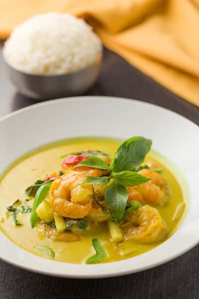 prawn green curry with vegetables and basil garnish