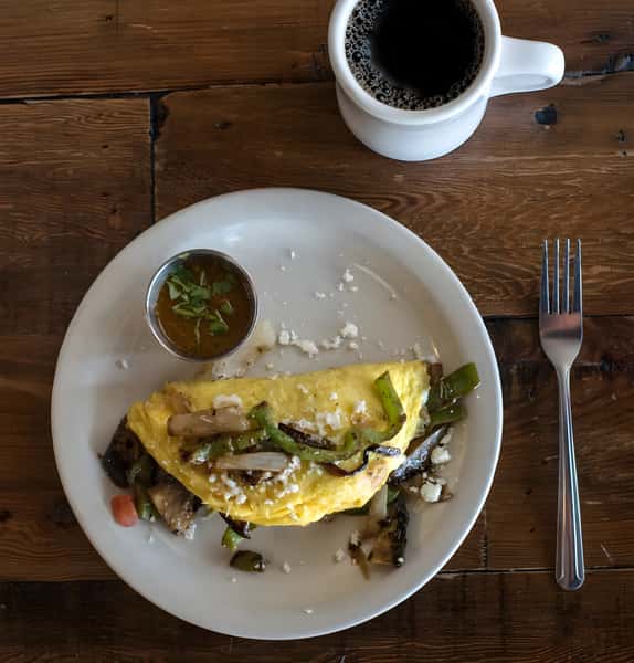 Breakfast omelet filled with asparagus and avocado, served with salsa.