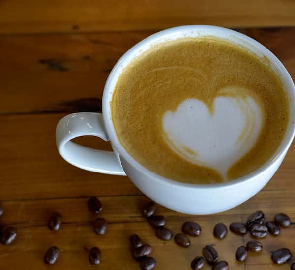 Hot latte with heart-shaped foam art.