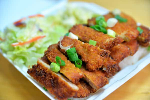 Crispy breaded cutlet slices served with fresh greens, offering a golden, crunchy texture and savory flavor in every bite.