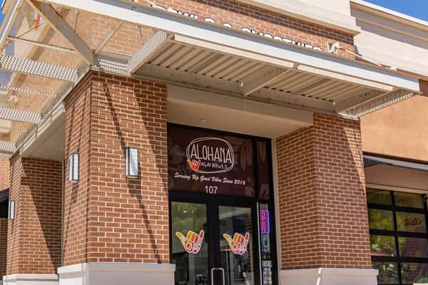 ALOHAHA Açaí Bowls storefront with brick exterior, glass doors, and signage reading "Serving Up Good Vibes Since 2016."