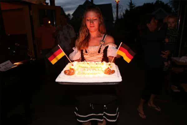 girl bringing out cake with german flags on it