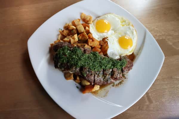 Hash Browns with two fried eggs and steak