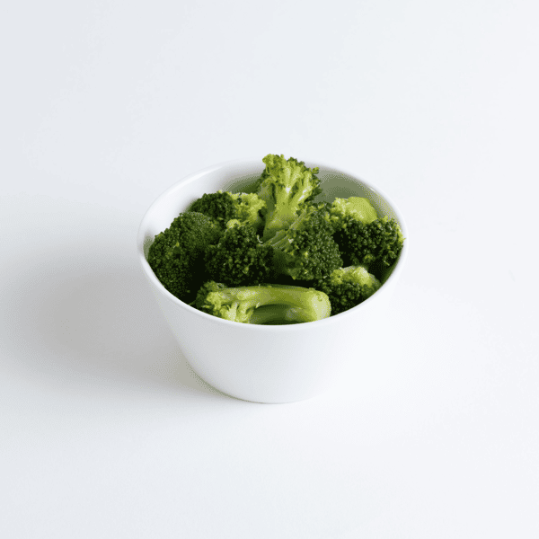 Steamed broccoli florets served in a clean white bowl, highlighting a healthy and vibrant green vegetable side option.