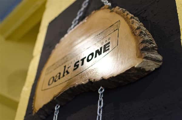 Engraved Oak Stone sign on trunk cross section of oak tree.