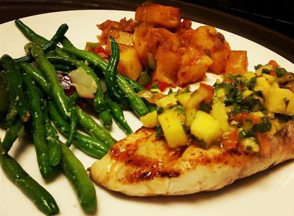 Grilled chicken topped with a mango salsa, green beans, and homefries