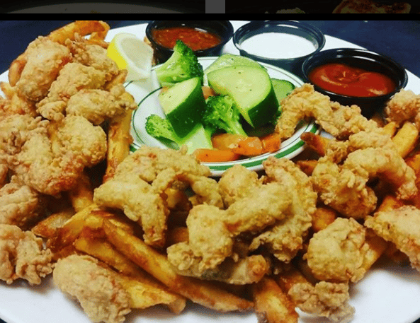 fried clams served with french fries, a bowl of mixed veggies and dipping sauces