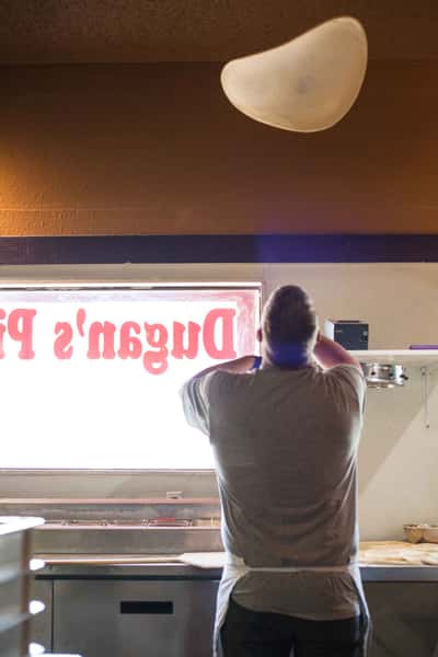 owner tossing pizza