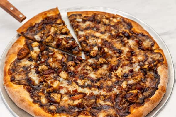 tuscan cowboy pizza topped with seasoned meat, cheese, and herbs on a crispy baked crust