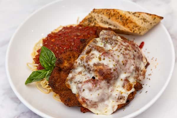 chicken parmesan with melted cheese and marinara sauce served over pasta with garlic bread
