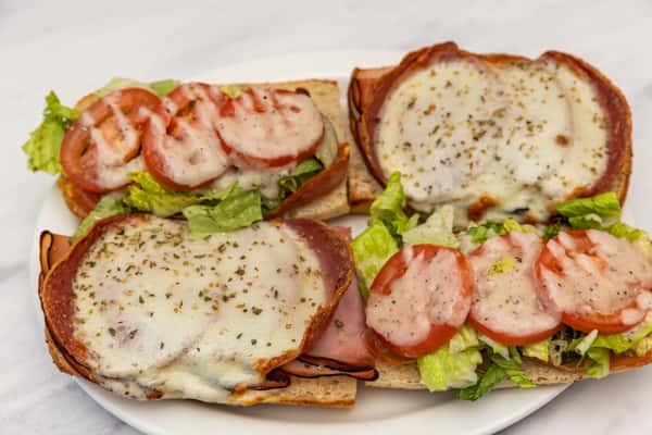 italian club sandwich with sliced meats, cheese, lettuce, and tomato served with toasted bread