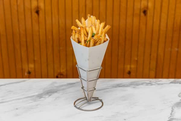truffle fries served in a cone topped with herbs and grated parmesan cheese