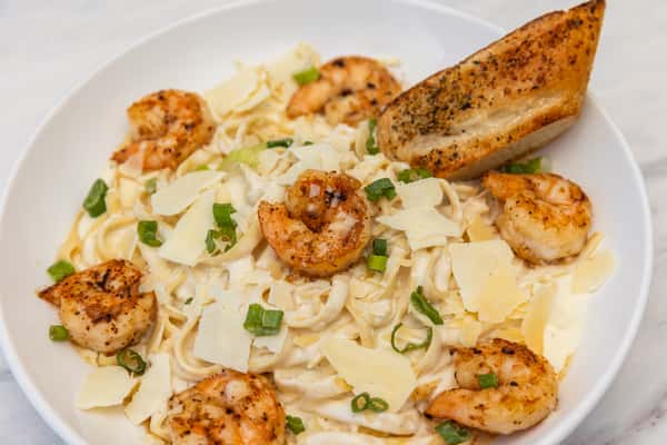 shrimp fettuccine pasta tossed in a creamy sauce with herbs and parmesan cheese