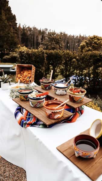 Bowls with different toppings and salsa on a table with chips