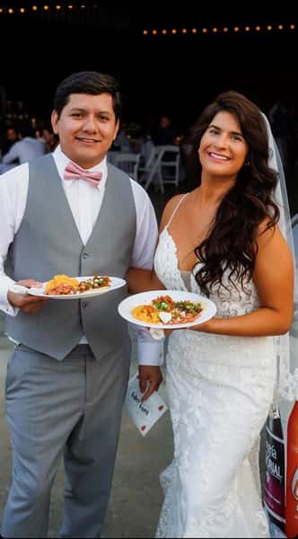 Bride and Groom at an event with two plates full of food